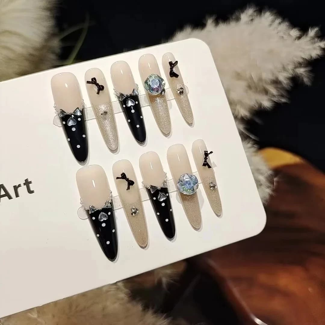 Čierne umelé nechty s motívom motýľa a kamienkami, manikúra Cat Eye s glitrami